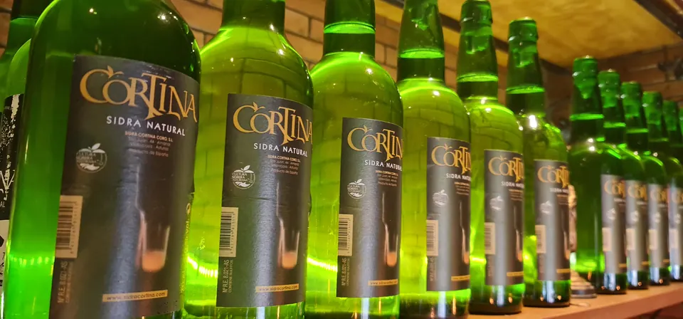Botellas de sidra natural asturiana Cortina alineadas en la sidrería